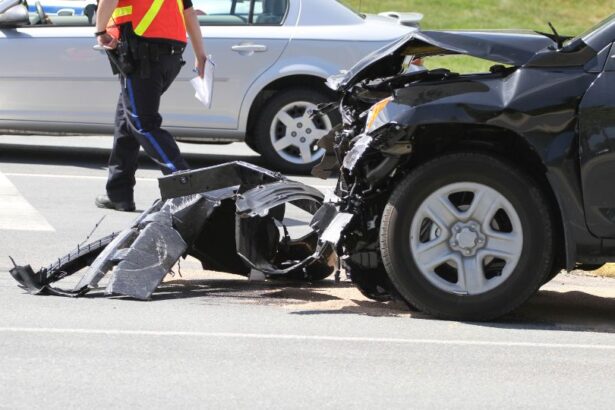 Un accident de mașină cu daune vizibile, un polițist investighează scena.