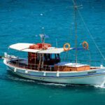 O barcă albă navigând pe ape turcoaz, simbolizând visuri și aventuri.