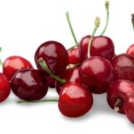 Cireșe roșii proaspete, strălucitoare, așezate pe o suprafață albă.