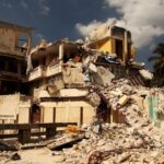 O clădire distrusă parțial, cu moloz și ruine, sub un cer înnorat.