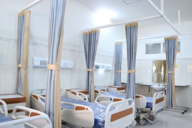 Interiorul unui spital cu paturi și perdele pentru intimitate.