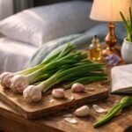 Usturoi verde proaspăt pe o masă lângă o carte și o lampă